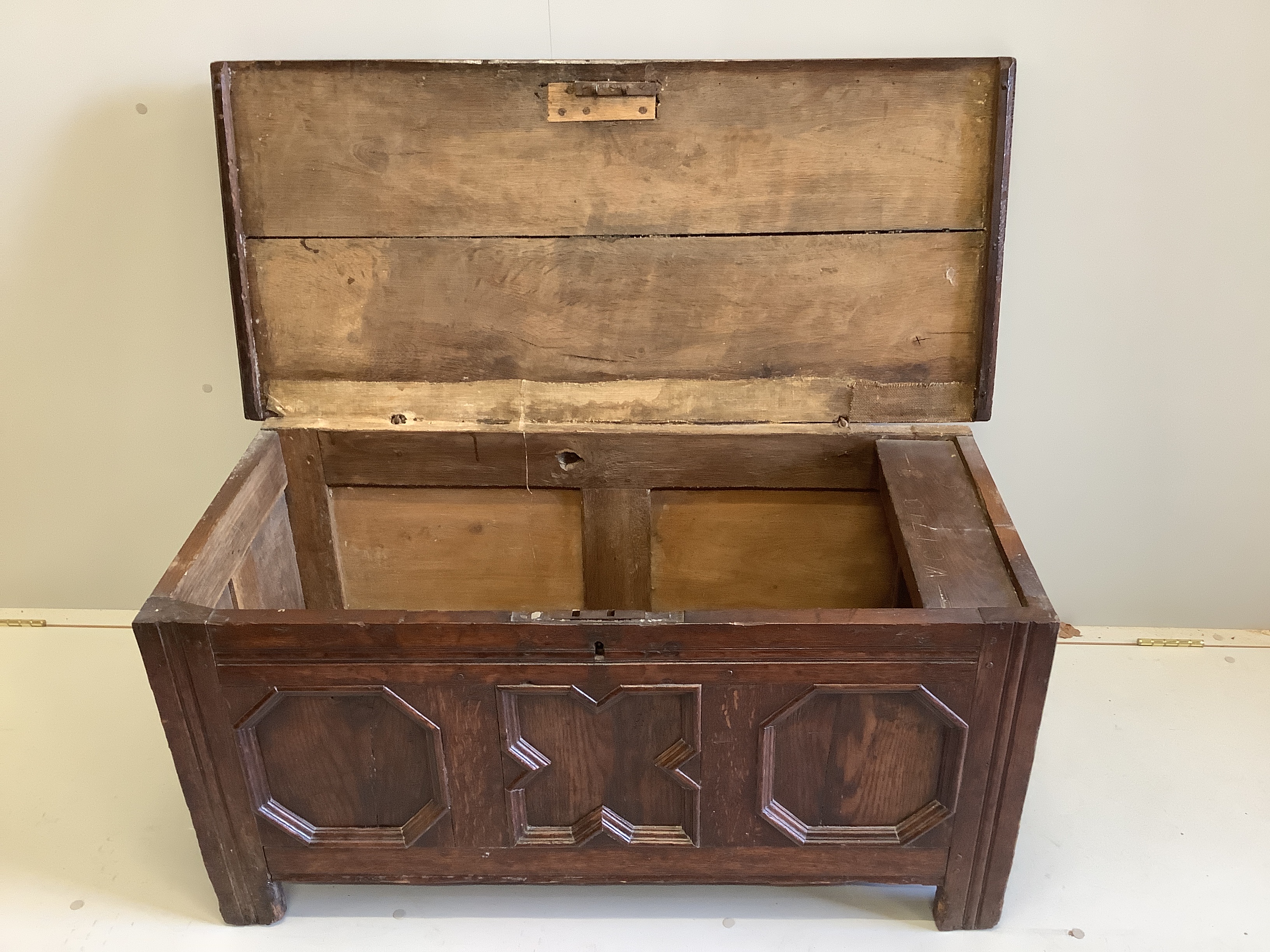 A small 17th century oak coffer with moulded geometric panelled front, width 108cm, depth 49cm, height 52cm